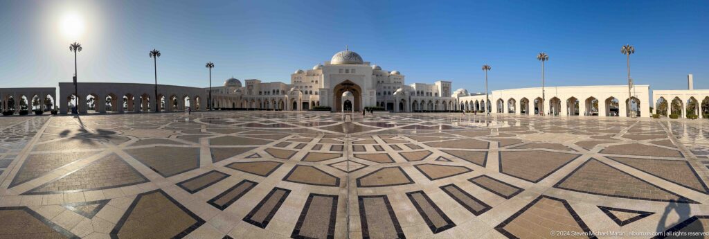 Low-angle view across patterned courtyard toward palace.