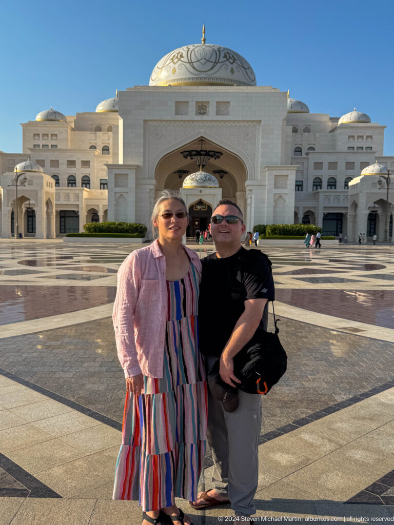 Two visitors standing together before palace.