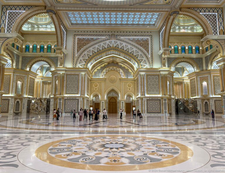 Symmetrical great hall view with circular floor design.