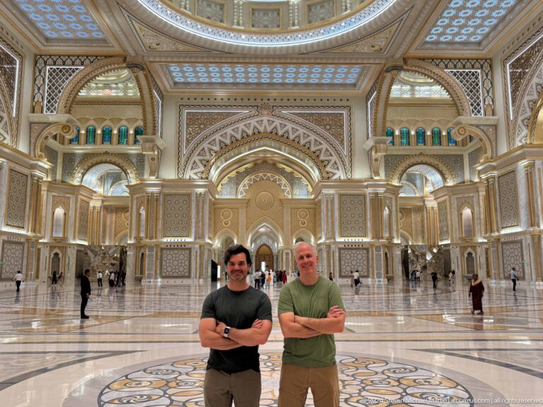 Two visitors posing inside great hall.