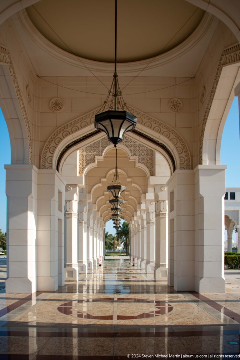 Long arcaded colonnade with hanging lanterns.