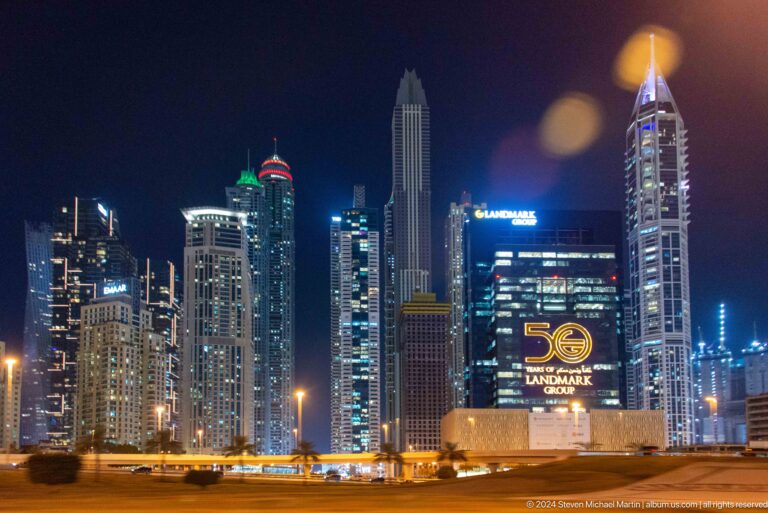 Cluster of illuminated Dubai high-rises against the night sky.