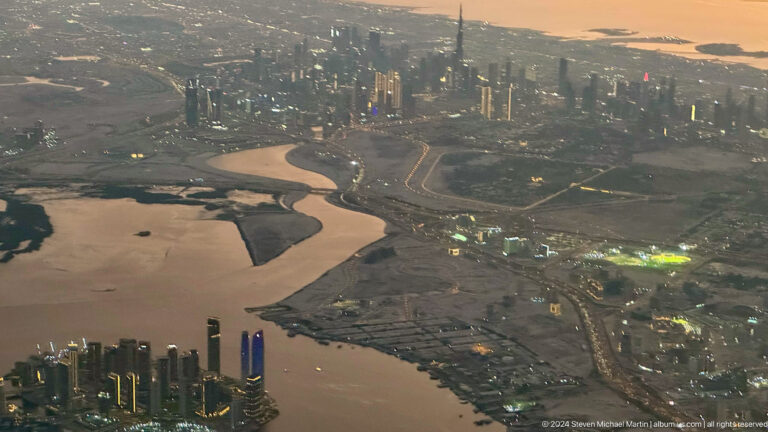 Aerial view of a water channel leading toward Dubai’s skyline.