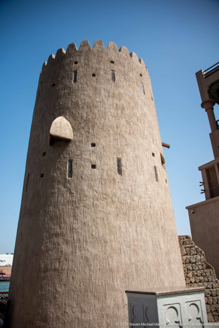 Close view of a round watchtower wall with small openings.