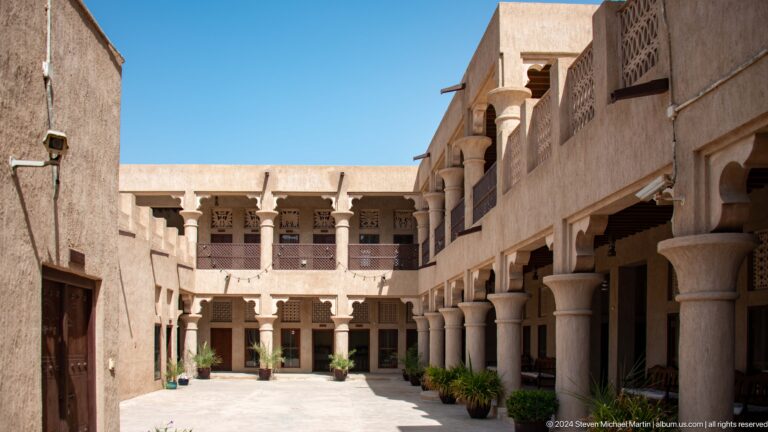 Sunlit courtyard enclosed by arcades and upper galleries.