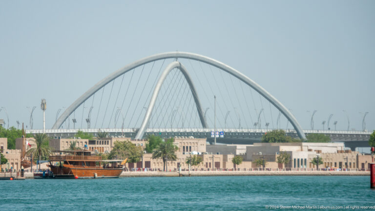 White arched Infinity Bridge spanning Dubai Creek.