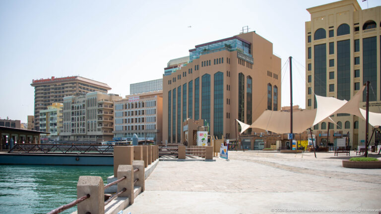 Waterfront buildings across turquoise water on Dubai Creek.