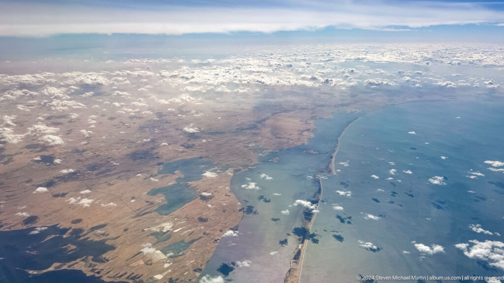 Aerial view of desert coastline, islands, and blue water near Dubai.