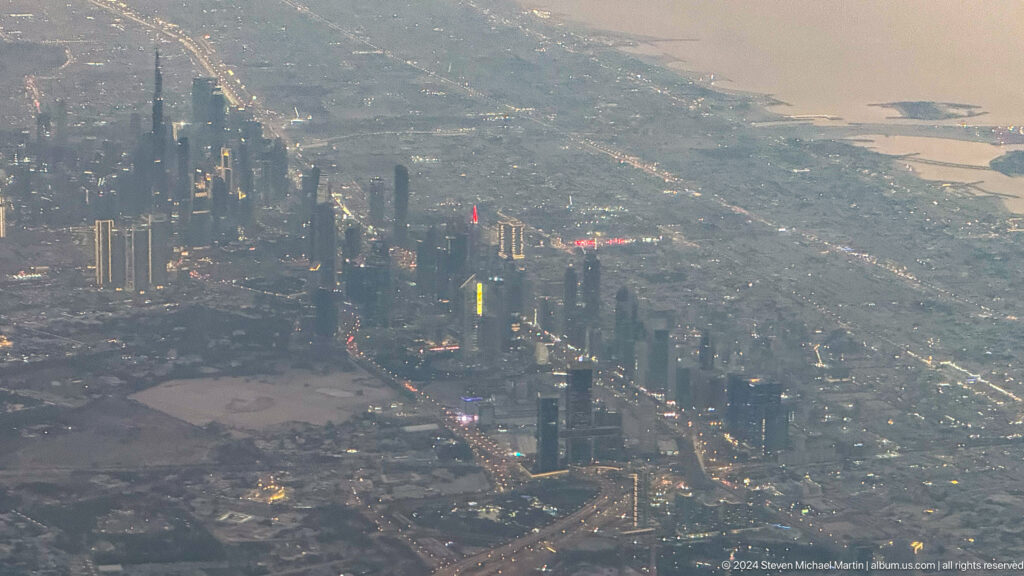 Aerial view of Dubai high-rises, highways, and dense urban development.