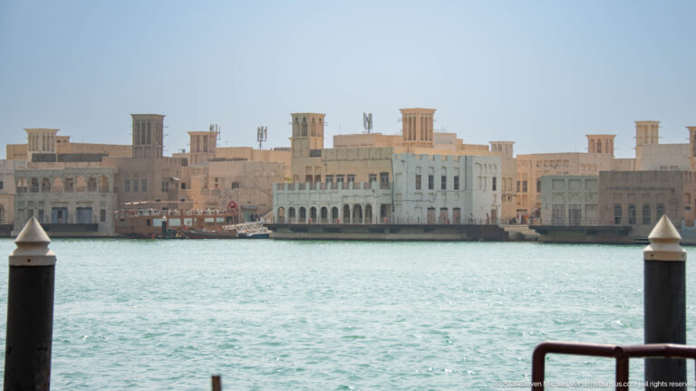 Traditional heritage buildings with wind towers across Dubai Creek.