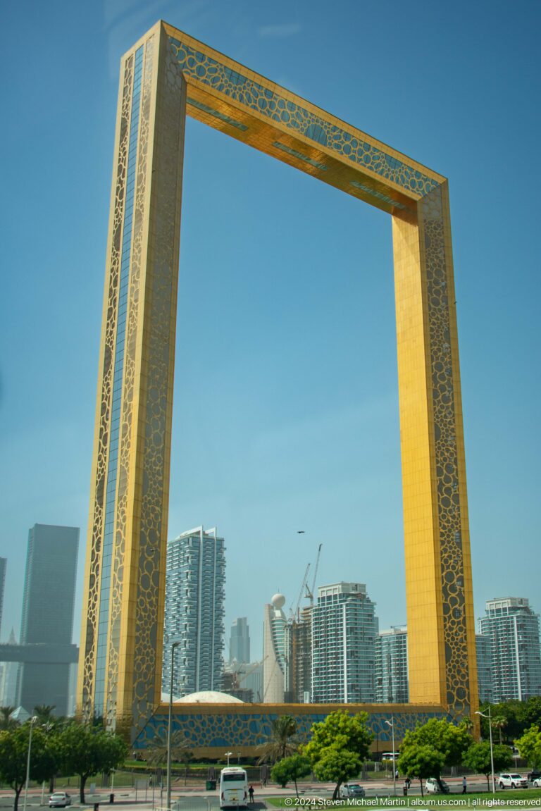 Tall golden architectural frame with repeating geometric ornament.