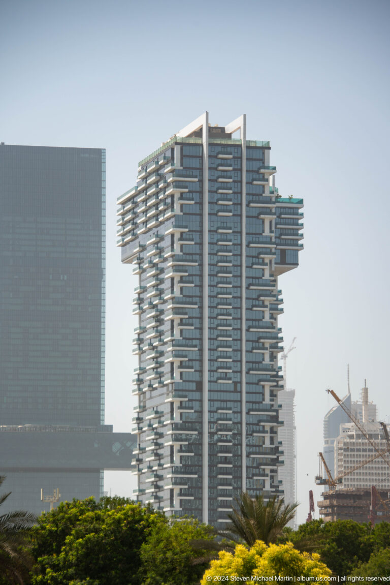 Tall Dubai tower with irregular projecting balconies.