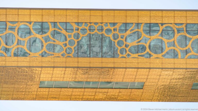 Golden façade covered in interlocking geometric lattice patterns.