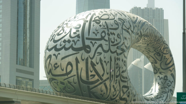Museum of the Future in daylight with Arabic calligraphy across its silver façade.