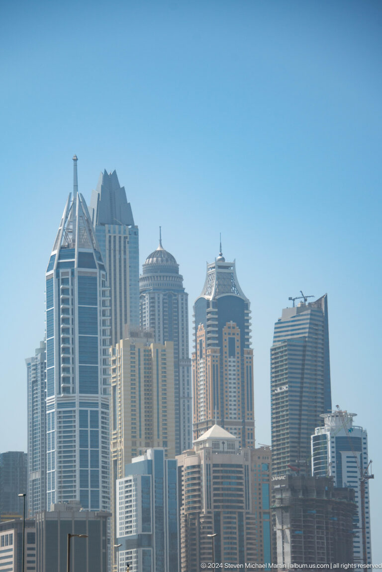 Cluster of ornate Dubai high-rises with pointed crowns.