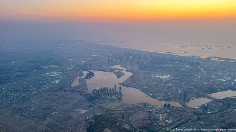 Aerial view of a winding waterway through Dubai’s urban development.