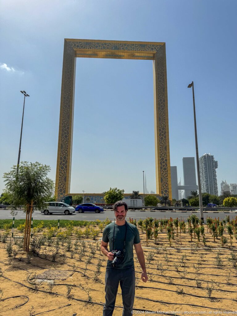 Man standing between the two uprights of Dubai Frame.