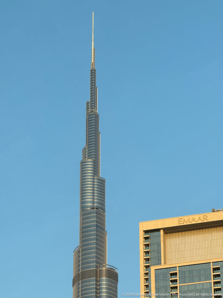 Close view of the tapering Burj Khalifa against a blue sky.
