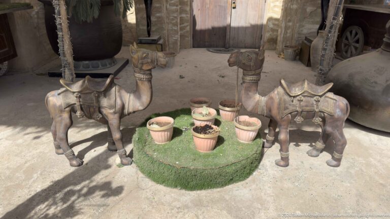 Ring of small animal figurines surrounding ceramic bowls on a low circular display platform in a heritage exhibit in Al Fahidi, Dubai.