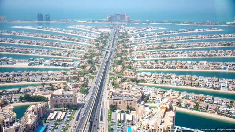 Central road of Palm Jumeirah extending through residential fronds toward Atlantis The Palm.