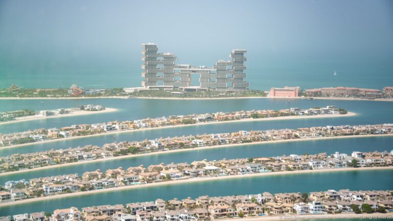 Atlantis The Royal rising beyond several Palm Jumeirah fronds lined with villas.