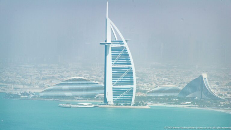 Burj Al Arab and the wave-shaped Jumeirah Beach Hotel seen across the water.