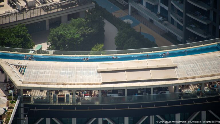 Blue elevated Palm Monorail track crossing above a station roof.