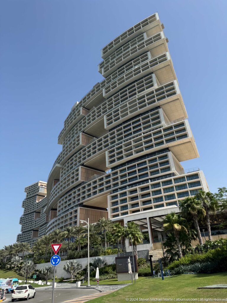Low-angle view of Atlantis The Royal's stacked balconies and cantilevered blocks above palms.