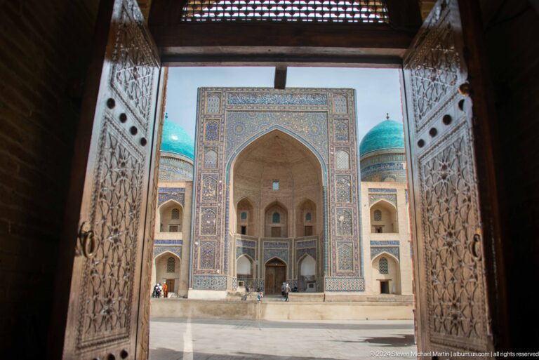 View through carved doorway toward madrasa portal.