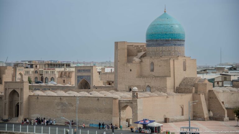 Turquoise dome above dense historic buildings.