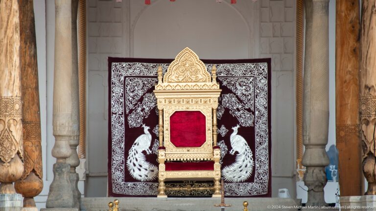 Ornamental throne with red cushion.