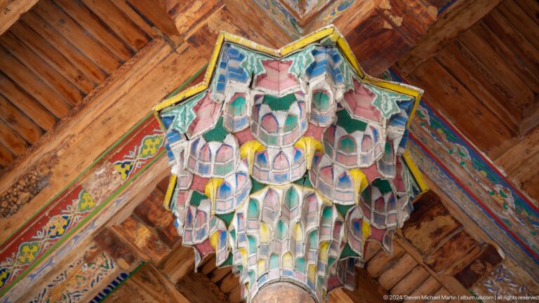 Close-up of a brightly painted, faceted wooden column capital.