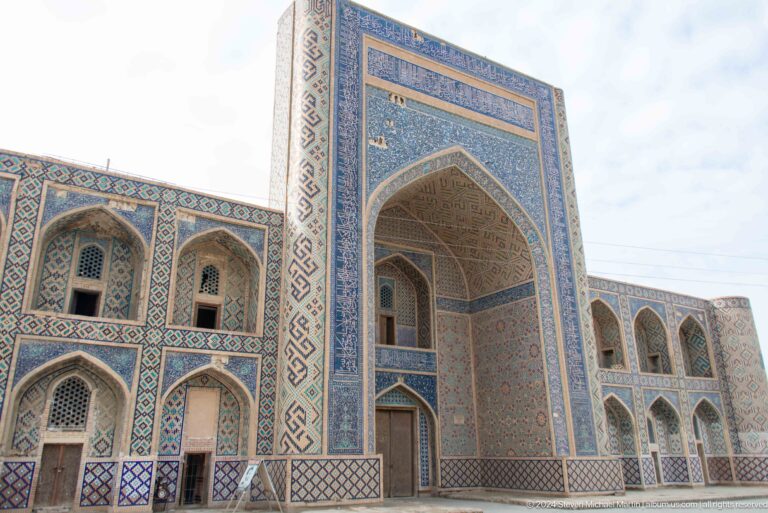 Monumental blue-tiled madrasa portal with two-story arched bays.