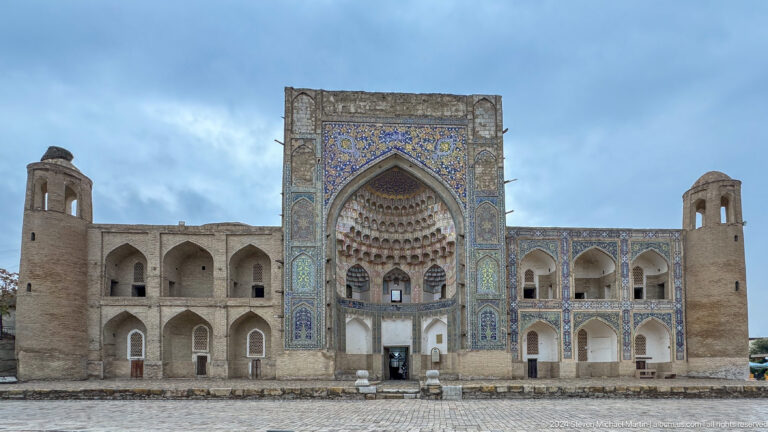 Courtyard façade with an ornate muqarnas iwan and two-story arcades.