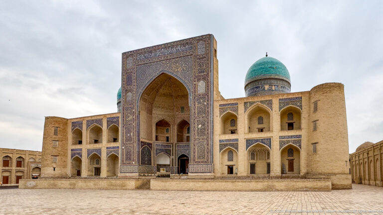 Mir-i-Arab Madrasa façade with a tiled portal and turquoise dome.