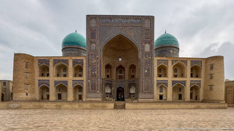 Frontal view of Mir-i-Arab Madrasa with two turquoise domes.