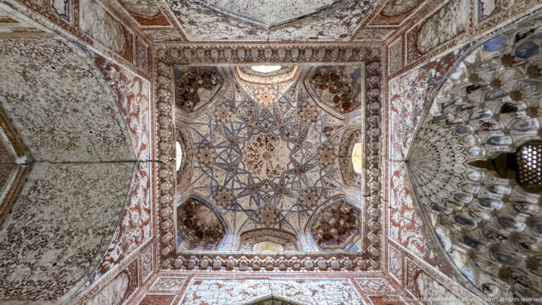 Ornate painted vault with central star geometry and muqarnas details.