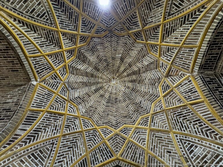 Radial woven ceiling forming an eight-pointed geometric star.