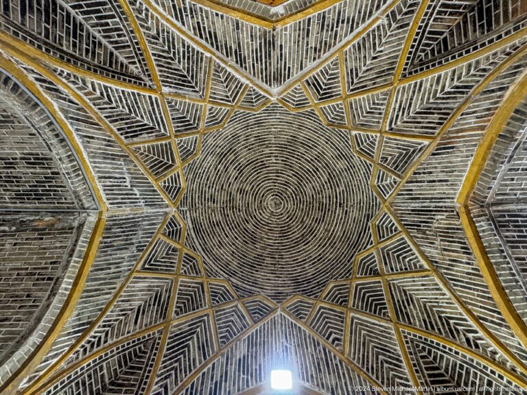 Concentric woven ceiling surrounded by angular star-pattern bands.