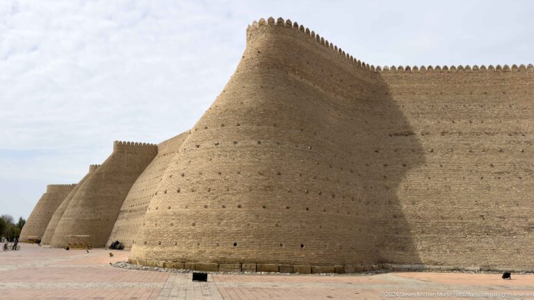 Angled view of the massive crenellated outer wall of the Ark of Bukhara.