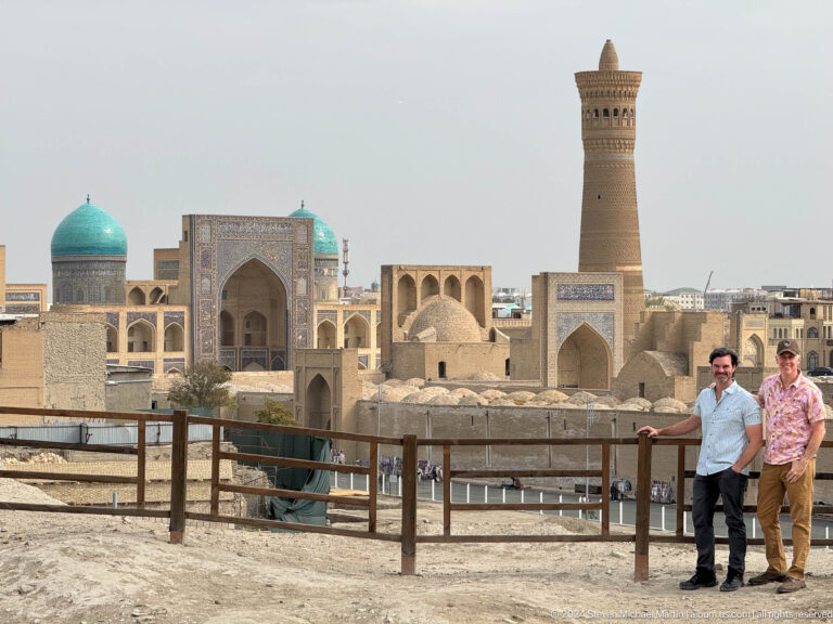 Two men posing above the Kalyan Minaret and Po-i-Kalyan complex.