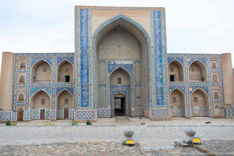 Broad madrasa courtyard facade with central iwan.