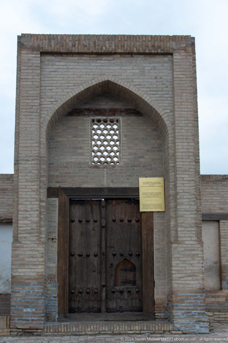 Wooden doorway below lattice window.