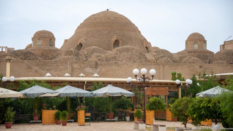 Large brick trading dome behind cafe awnings.