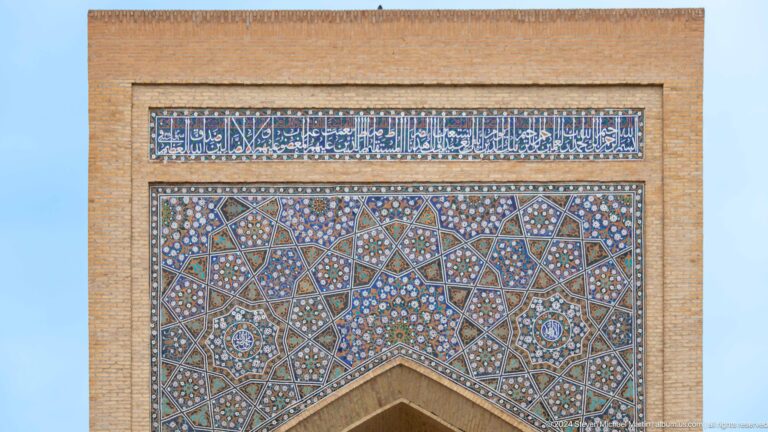 Rectangular calligraphic tile panel above arch.