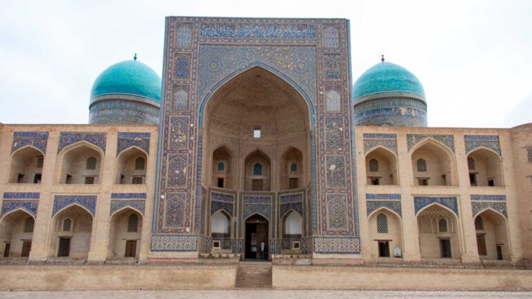 Frontal view of madrasa portal and two domes.