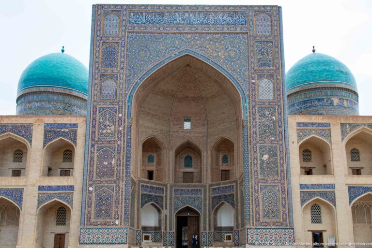 Central madrasa portal flanked by turquoise domes.