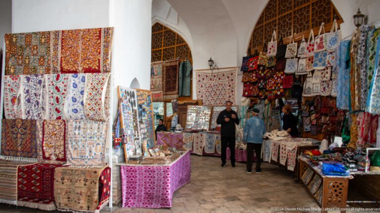 Indoor carpet and textile market with shoppers.