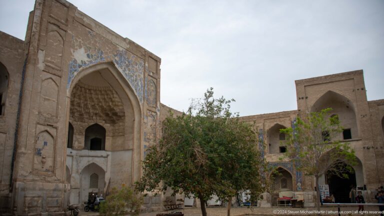 Courtyard with trees before monumental portal.