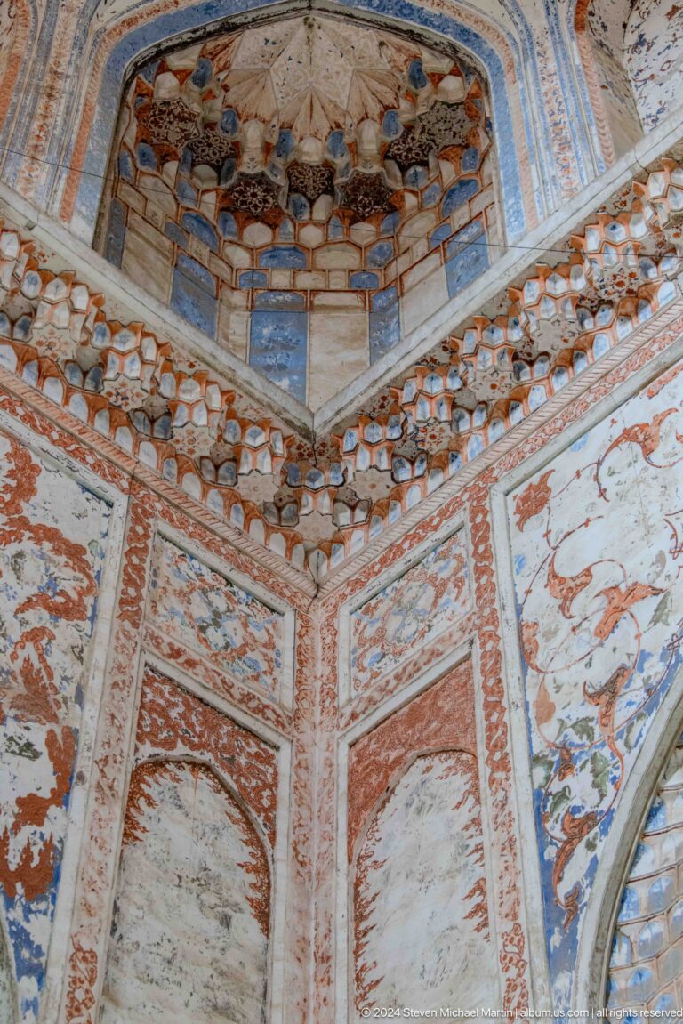 Painted wall and ceiling corner with floral bands.